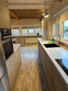 una cucina con ripiani bianchi e pavimenti in legno di Villa Svane a Rødby