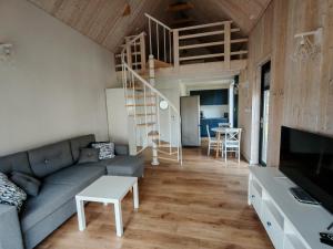 a living room with a couch and a staircase at Całoroczny domek Morze in Ustka
