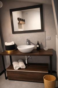 een badkamer met een wastafel en een spiegel bij ES Apartments in Nago-Torbole +24 foto's