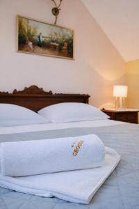 een bed met een witte handdoek erop bij Pensiunea Crocus - Sauna & Billiard in Poiana Brasov