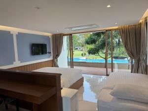 een slaapkamer met 2 bedden en uitzicht op een zwembad bij Monte Viento Khaoyai  +42 foto's