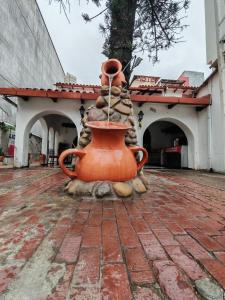 een grote oranje vaas staat op een bakstenen ondergrond bij Hotel lider in Santa Cruz de la Sierra