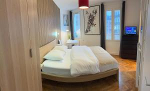 een slaapkamer met een bed met witte lakens en kussens bij Studio number 9 in Pantin