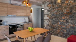 una cucina con un tavolo di legno e un muro di mattoni di Lindos Summer Memories Villas a Líndos
