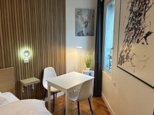 een kleine kamer met een witte tafel en stoelen bij Studio number 9 in Pantin