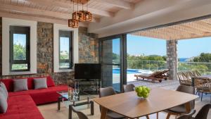 un soggiorno con un divano rosso e un tavolo di Lindos Summer Memories Villas a Líndos