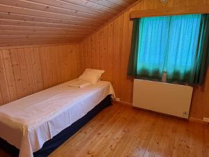 een kleine slaapkamer met een bed en een raam bij A comfy House in Hol