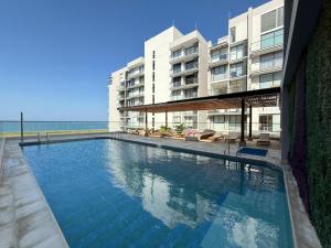 a swimming pool in front of a building at Edificio Salinas del Mar - Pozos Colorados in Santa Marta