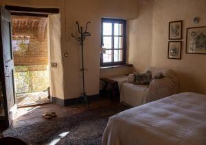 ein Schlafzimmer mit einem Bett und einer Couch und einem Fenster in der Unterkunft Cascina Zan in Paroldo