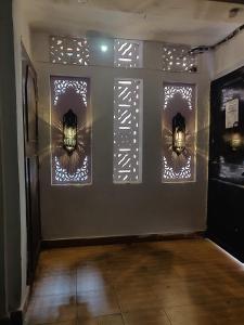 a room with three windows with lights on the wall at Green Olive GoStays Best Dormitory and Rooms in Lucknow in Lucknow +6 photos