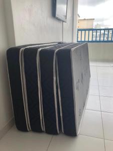 une valise posée sur le sol dans une pièce dans l'établissement Pitangueiras Apartment, great location, oceanfront, à Guarujá