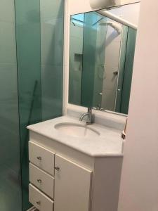 une salle de bains avec un lavabo et un miroir dans l'établissement Pitangueiras Apartment, great location, oceanfront, à Guarujá 10 autres photos