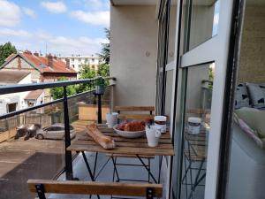 une table avec un bol de nourriture sur un balcon dans l'établissement Appart'HomeCity - Rouen Grand Prieuré - 1 à 3 chambres, à Rouen