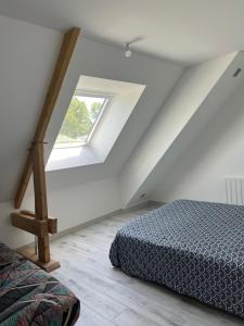 a attic bedroom with a bed and a window at Reinettes in Mulsanne