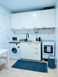 een keuken met witte kasten en een wasmachine bij Tree House II in Setúbal +10 foto's