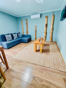 een woonkamer met een blauwe bank en een tafel bij Tree House II in Setúbal