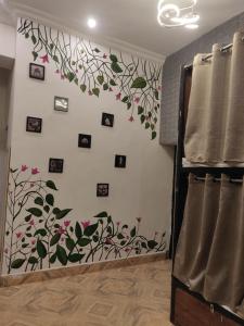 a room with a wall with flowers and pictures at Green Olive GoStays Best Dormitory and Rooms in Lucknow in Lucknow