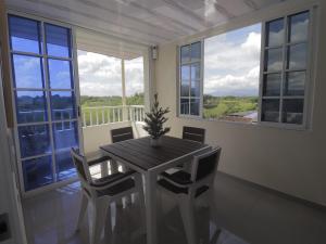 een eetkamer met een tafel, stoelen en ramen bij Hotel Alcalá in Alcalá