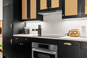 una cucina con mobili neri e un forno a piano cottura di Freeman 602 by Rove - Condo with Shared Amenities a New York Altre 24 foto