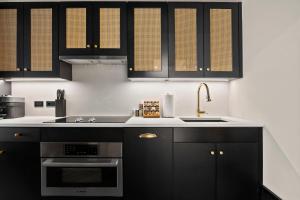 una cucina con armadi neri e lavandino di Freeman 602 by Rove - Condo with Shared Amenities a New York