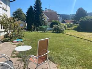 a chair in a yard with a table and a lawn at Ferienhaus Wolfurt in Wolfurt