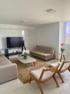 een woonkamer met een bank en een tv bij Casa Campos do Mar in Conde