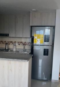 a kitchen with a stainless steel refrigerator and a counter at Apartamento confortable, excelente ubicacion in Ibagué
