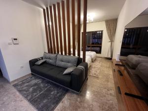 un salon avec un canapé et un lit dans l'établissement Mazaya VIP Stay, à Mawāliḩ