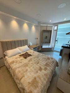 a bedroom with a large bed and a desk at Tiny Spot in Ocaña