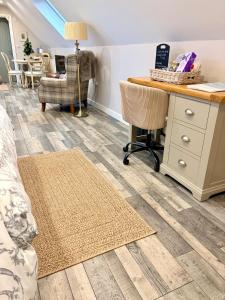 een woonkamer met een bureau en een tafel en stoelen bij The Honeysuckle Coop in Grantham