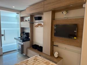 a living room with a flat screen tv and a kitchen at Tiny Spot in Ocaña