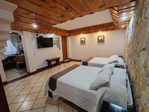a hotel room with two beds and a television at Hotel Cibeles Resort in Heredia