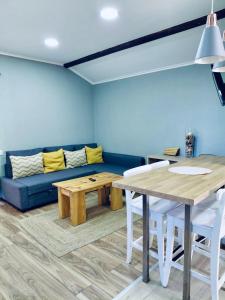 een woonkamer met een blauwe bank en een tafel bij Tree House III in Setúbal +12 foto's