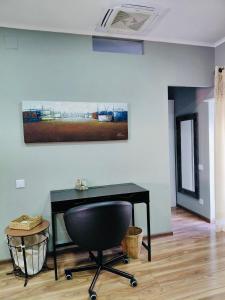 een bureau en een stoel in een kamer met een schilderij bij Tree House III in Setúbal