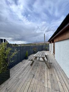 a wooden deck with a bench on a house at Sheraton Apartments in Fort William