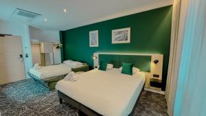 een slaapkamer met twee bedden en een groene muur bij Best Western Voiron Centre in Voiron +72 foto's