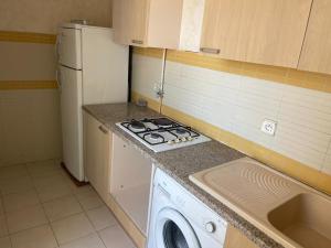 a kitchen with a stove and a washing machine at حي النصر 2 in Ariana