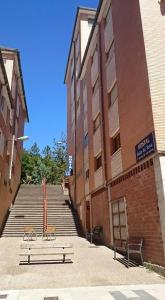 un grupo de bancos sentados frente a un edificio en Hostal Valle De Tena, en Sabiñánigo