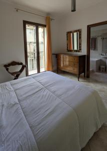 a bedroom with a bed and a dresser and a mirror at Casa Migliore - con garage privato in Scicli