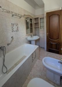 a bathroom with a tub and a toilet and a sink at Casa Migliore - con garage privato in Scicli