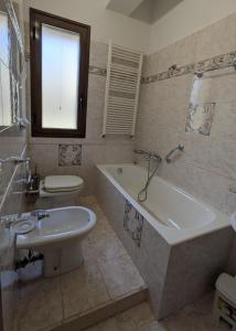 a bathroom with a tub and a toilet and a sink at Casa Migliore - con garage privato in Scicli