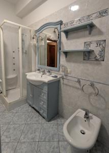 a bathroom with a sink and a toilet and a mirror at Casa Migliore - con garage privato in Scicli
