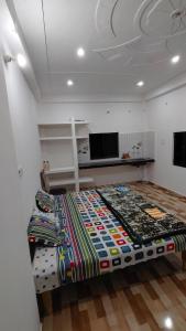 a bedroom with a bed with a colorful comforter at Ajay homestay &PG in Jhūsi
