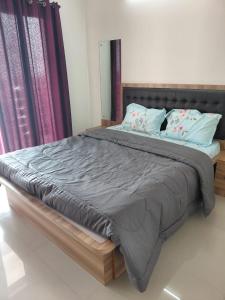 a bedroom with a large bed with a wooden frame at Sosh service apartments in Mangalore