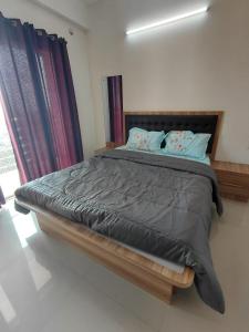 a bedroom with a large bed with blue pillows at Sosh service apartments in Mangalore