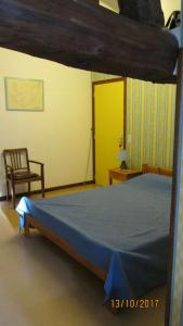 une chambre avec un lit et une chaise dans une pièce dans l'établissement La vache sur le toit, à Montagny