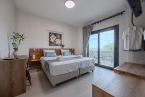 een slaapkamer met een bed en een groot raam bij Dina Villa in Roumelí +37 foto's