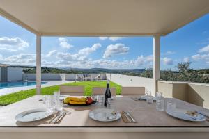 een eettafel met een fles wijn erop bij Dina Villa in Roumelí