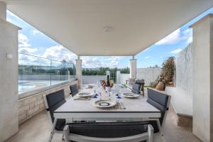 een eetkamer met een tafel en stoelen op een balkon bij Pelagia villa in Roumelí