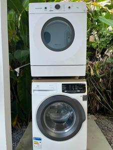 a washing machine with a microwave on top of it at Casa no Centrinho para 2 pessoas 100m do Mar in Bombinhas